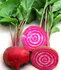 Chioggia Beets, one sliced with red and white rings and one whole in red grown from seeds