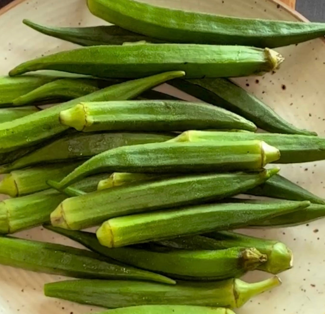 cut green okra in a pile in a white bowl from seeds